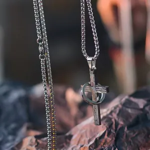 Detailed close-up of a stainless steel cross necklace with engraved religious text