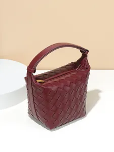 Elegant burgundy handmade woven leather handbag with top handle and a gold zipper