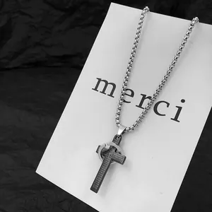 Detailed macro view of a stainless steel cross necklace with a ring pendant design