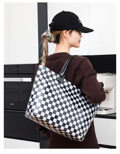 Woman wearing a stylish black and white checkerboard PVC tote bag in a kitchen setting