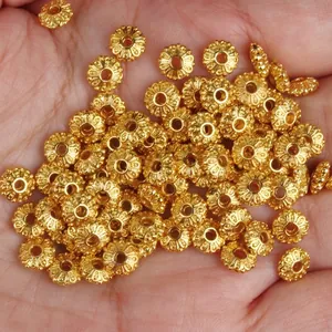Macro view of detailed 18k gold-plated wheel spacer beads for DIY jewelry components.