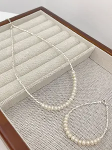 Detailed view of minimalist s925 silver necklace and bracelet set with natural pearls