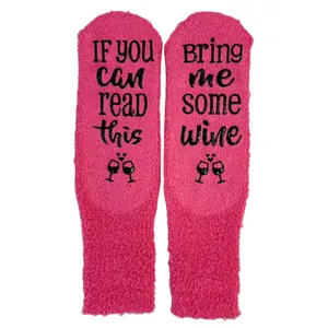 Cozy fuzzy pink coral fleece socks featuring 'Bring me some wine' non-slip sole text