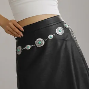 Detailed shot of vintage silver sunflower waist chain with turquoise stones on a black skirt