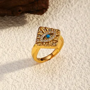 Close-up view of vintage gold-plated evil eye ring featuring turquoise and pavé stones