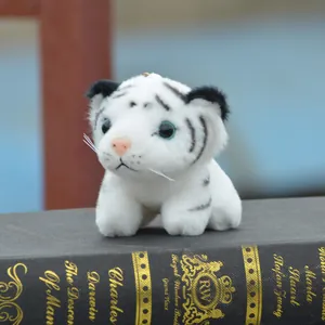 Gros plan d'un mignon porte-clés tigre blanc en peluche sur un livre.