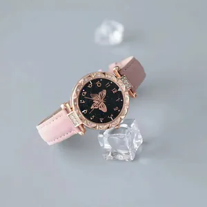 Detailed view of pink leather strap quartz watch with rhinestone starry butterfly dial.