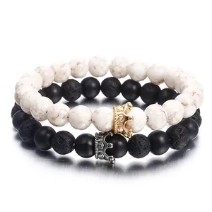 Macro detail of black lava stone and white marbled beaded bracelets with metallic crown charms