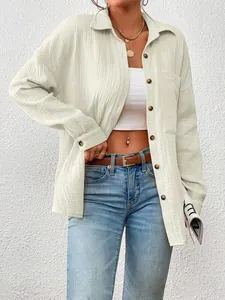 Close-up of casual oversized long-sleeved button-down shirt for women in textured fabric