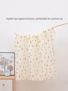 Vue détaillée d'une douce couverture bébé en mousseline de coton à motifs oranges