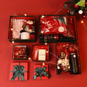 Festive Christmas gift box sets with holiday ornaments and various sweet treats