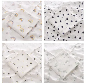 Détail de langes en mousseline de coton pour bébé avec quatre motifs adorables.