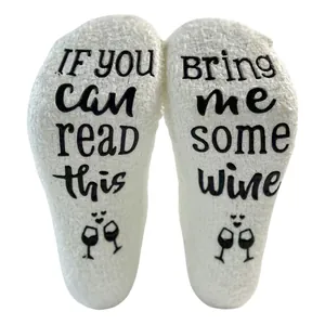 Soft white coral fleece floor socks with 'Bring me some wine' anti-slip text detail.