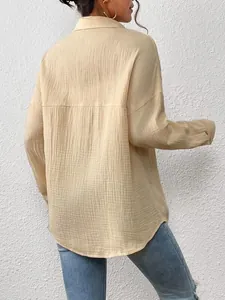 Back view of a minimalist oversized long-sleeved cream shirt with textured gauze fabric.