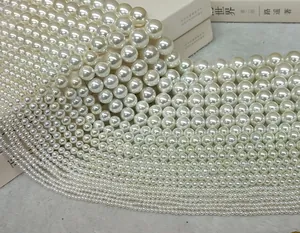 Close-up view of high-luster white imitation pearls in various sizes for DIY jewelry projects.