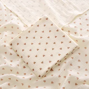 Détail d'une couverture d'emmaillotage en mousseline de coton doux à motifs cœurs