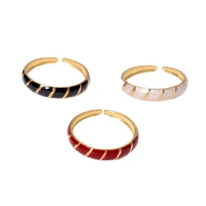 Detailed view of three vintage adjustable enamel rings in black, white, and red.