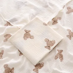 Gros plan du lange pour bébé en mousseline de coton doux avec un motif d'ours brun