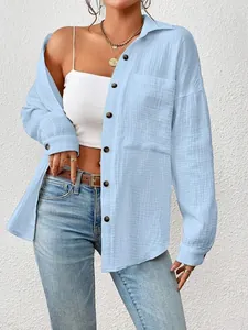 Detail of light blue muslin long sleeve shirt with drop shoulder and buttons