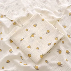 Gros plan d'un lange en mousseline de coton pour bébé avec un motif de citron jaune