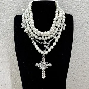 Detailed view of heavy multi-layered pearl necklace featuring silver-tone rose cross pendants