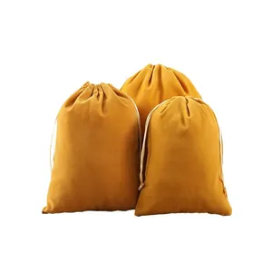 Set of three mustard yellow velvet drawstring bags for jewelry storage and gift packaging.