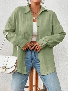 Close-up of sage green textured shirt showing drop-shoulder and button details