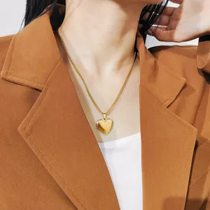 Mooie detailopname van een gouden hartvormige roestvrijstalen ketting bij blazer.