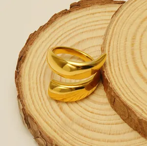 Close-up of golden titanium steel open ring with smooth mirror finish on wood