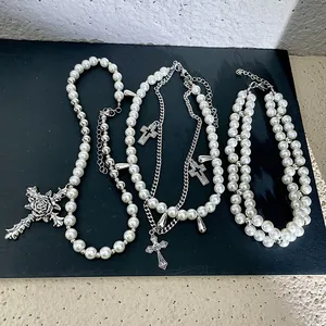 Layered pearl necklace set with silver cross pendants and rose detail, gothic style.