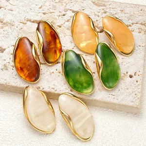 Collection of irregular resin stud earrings in amber, green, and cream colors