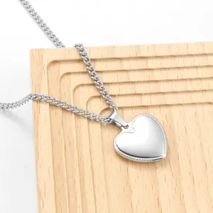Detailopname van een minimalistische zilverkleurige hartvormige roestvrijstalen ketting