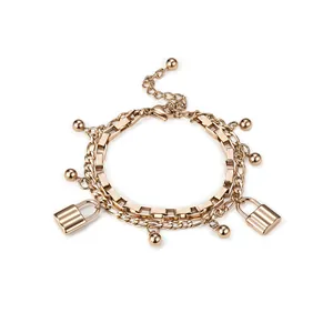 Vue détaillée d'un bracelet double couche or rose avec des charms cadenas élégants.