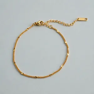 Detailed view of a gold-plated stainless steel geometric Cuban chain bracelet.