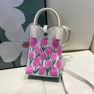 Detailed view of cream knitted mini tote bag with pink tulip pattern and metal button