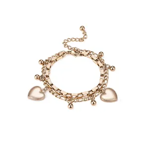 Vue détaillée d'un bracelet doré à deux rangs avec des breloques en cœur et billes