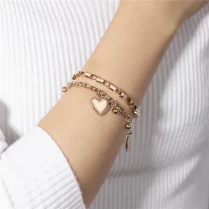 Vue détaillée d'un élégant bracelet double couche en acier titane avec cœur doré