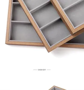 Détail d'un présentoir à lunettes en bois minimaliste avec intérieur en velours gris