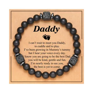 Close-up detail of matte black beads and lava stone bracelet on a Daddy message card