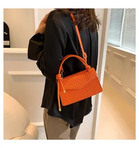 Vibrant orange vintage flap shoulder bag shown from a back view on model outfit
