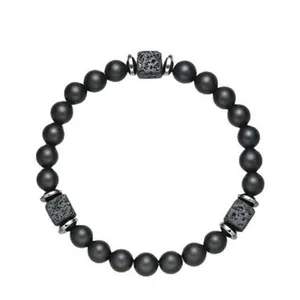 Detail shot of matte black beads and square lava stone spacers on a beaded bracelet.