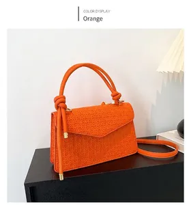 Elegant orange textured crossbody bag with decorative top handle and slim strap