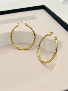Elegant large gold-plated hoop earrings featuring a unique textured striped finish.