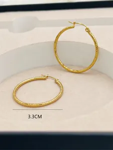 Detailed view of 3.3cm diameter gold hoop earrings with elegant striped engraved pattern