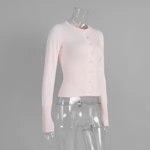 Elegante cardigan rosa attillato in maglia a maniche lunghe con bottoni su fondo grigio