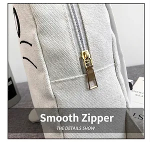 Close-up macro shot showing the smooth golden metal zipper on a white canvas cat backpack