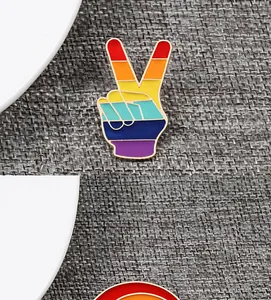 Detailed macro view of a rainbow striped V-sign peace hand enamel pin badge accessory