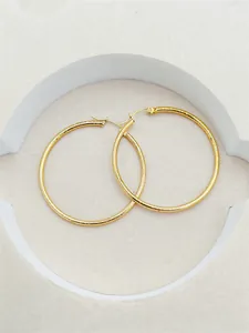 Close-up detail of elegant 24K gold plated large hoop earrings with textured stripes