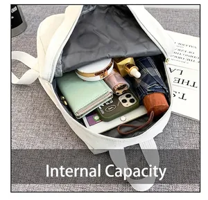Detailed view showing the interior capacity of the white backpack with daily essentials.