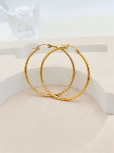 Detailed view of 24K gold plated hoop earrings with elegant striped textured finish